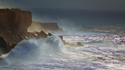 Powerful ocean hitting cliffs on stormy day. Dramatic waves breaking rocks make