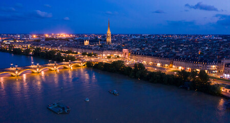 Picturesque view from drone of illuminated modern cityscape of French port city of Bordeaux on river Garonne and Stone Bridge