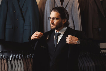 Shop store clothes for men. Businessman in classic vest puts on suit jacket