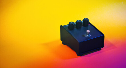 Analog guitar distortion pedal in a bright background, with copy space. A retro guitar music...