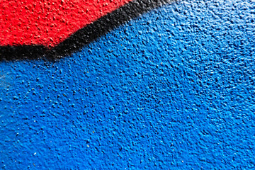 Abstract wall surface with part of graffiti. Geometric lines, light blue, black, red colors...