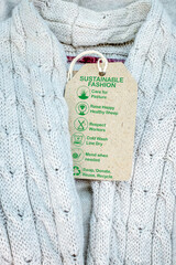 sustainable fashion label on wool jumper with green care icons and text, eco ethical consumerism