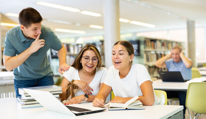 Obraz premium Young librarian tells students to be quiet in public library
