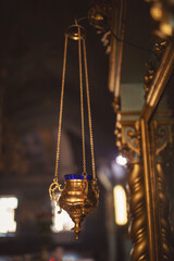 A closeup shot of a sanctuary lamp in the church. Orthodox Church. Christianity. Festive interior decoration with burning candles and icon in traditional Orthodox Church on Easter Eve or Christmas.