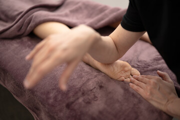 Masseur Providing a Deep Tissue Leg Massage at Spa - obrazy, fototapety, plakaty