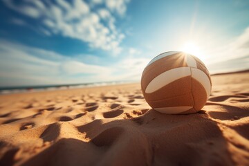 Close-up of a volleyball on a sunny beach with blue skies.