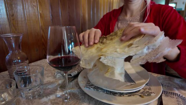 lady indulging in flavors of a Borlengo, a classic dish from Emilia-Romagna, Italy. Particularly cherished in the provinces of Modena and Bologna, this dish is a harmonious fusion of meat and cheese.