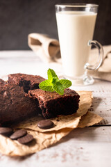 Stack of chocolate brownies with milk glass on dark stone background, homemade bakery and dessert