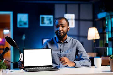 African american tech expert presenting mockup laptop in entry level low budget price range. Viral content creator reviewing isolated screen notebook in front of internet fanbase