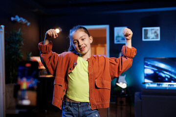 Entertaining kid in dimly lit personal studio joins viral dance craze, recording family friendly...