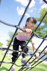 A girl is playing climbing and exercising at the playground.