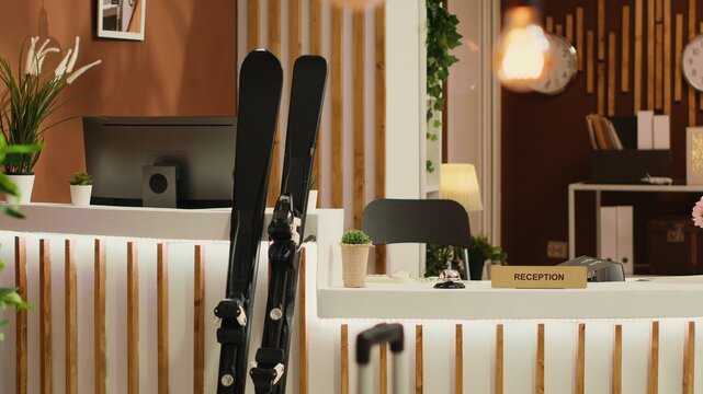 Empty cold season ski resorts where winter sports lovers are hosted in hotel reception. With safety helmets, sporting apparel and snowboarding equipment in salon, travellers have reservations.