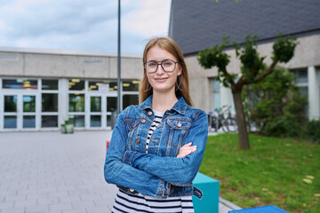 Portrait of teenage high school student girl with backpack, outdoor