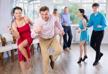 Fototapeta na wymiar Adult couple dancing and practicing in dance class