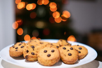 Galletas con pepitas de chocolate con árbol de navidad al fondo 