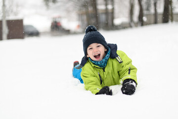 Fototapeta na wymiar Young Boy Enjoying Himself While Playing in Snow