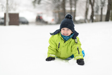 Fototapeta na wymiar Young Boy Enjoying Himself While Playing in Snow