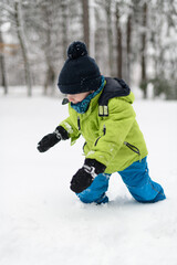 Fototapeta na wymiar Little Boy is Having Fun Playing With Snow