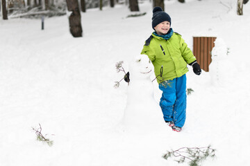 Fototapeta na wymiar Happy Little Kid is Playing in Snow