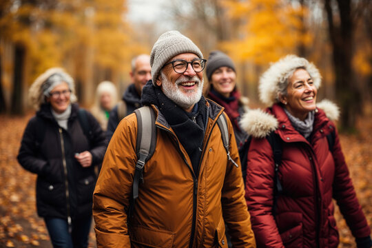 Generative AI image of a group of happy seniors walking in an autumnal forest, enjoying the seasonal colors and outdoor activity