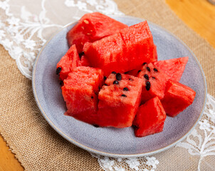 Service plate containing fresh watermelon pieces with other table appointments