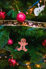 Árbol de Navidad decorado con bolas rojas y muñeco con forma de galleta de jenjibre