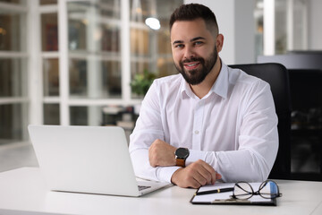 Obraz premium Portrait of smiling man at table in office. Lawyer, businessman, accountant or manager