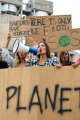 Vertical photo of Group diverse people of demonstrators protesting against climate change. Woman...