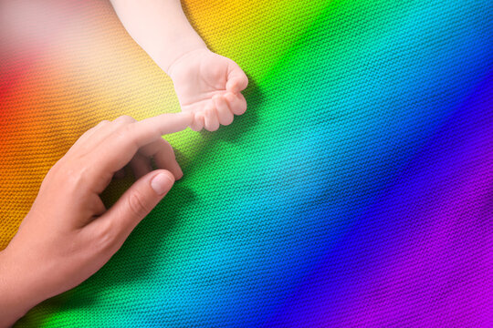 National rainbow baby day. Mother and her little child baby on colorful blanket, top view. Space for text