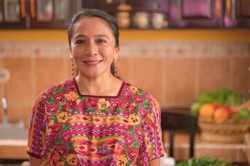 Portrait of a woman looking at the camera, wearing a colorful blouse from the region.