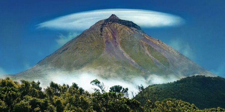 Pico volcano with a lenticularis cloud in the blue sky, surrounded by vegetation, Gruta das Torres, Pico Island, Azores, Portugal, Europe