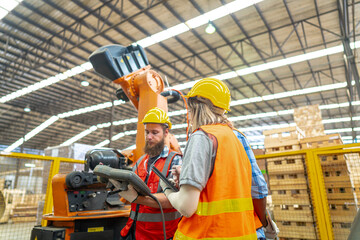 team Engineers standing by robotic arm and operating machine in factory. worker man control on tablet. Workers work at heavy machine robot arm. High-tech robot with a remote system in Wood factory.