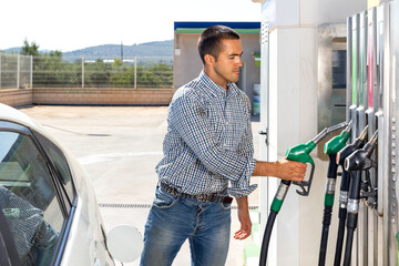 Man filling up tank of his car with gasoline in gas station