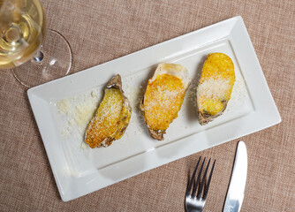 In center of photo are oysters served with aged Cava wine. Oysters on curly halves of shells....