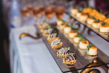 Beautifully decorated banquet catering table, with variety of with different food snacks appetizers...