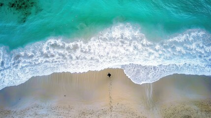 Fototapeta na wymiar aerial view of a beautiful beach with blue waves coming to shore, one man standing alone on the beach, backdrop