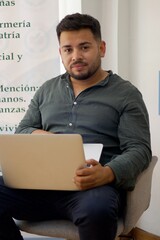 latin man sitting with a laptop