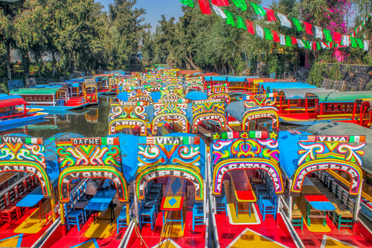 Mexico City, Mexico. Jan 15, 2024. An horizontal view of Several Trajineras or gondolas style boats, or colourful rafts parked along the Xochimilco canal.