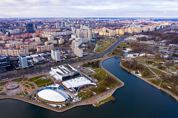 Obraz premium View from drone of downtown Minsk with modern residential neighborhoods and indoor sports arena on banks of Svislach river on winter day, Belarus..