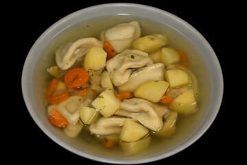 Pelmeni-Suppe/Eintopf mit Kartoffeln, Möhren und Zwiebeln.
