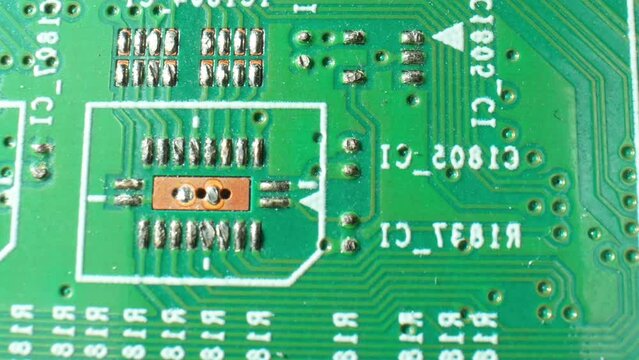A Printed Circuit Board (PCB) is like a technological roadmap, guiding electrical signals through a maze of copper traces, ensuring devices function smoothly. Close-up footage. Technology concept.
