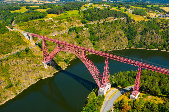 Scenic drone view of parabolic arched framework of railway bridge Viaduc de Garabit across river Truyere near Ruynes-en-Margeride in Auvergne, France..