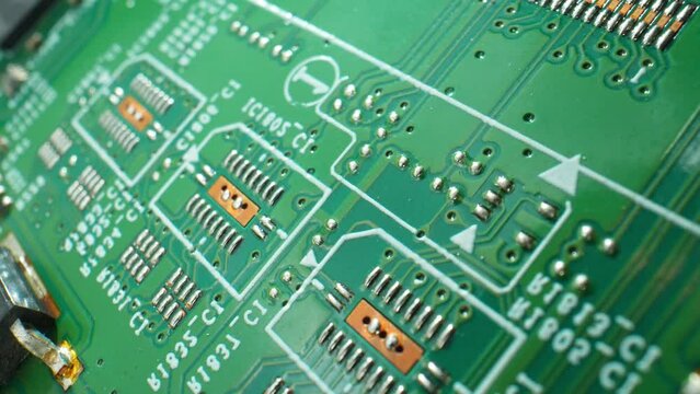 Explore the intricate world of electronics with a captivating macro video of a Printed Circuit Board (PCB), unveiling its intricate pathways. Close-up footage. Electronic devices concept.
