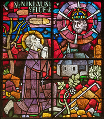 BERN, SWITZERLAND - JUNY 27, 2022: The St. Nicholas of Flue on the stained glass in the church Dreifaltigkeitskirche by A. Schweri (1938).