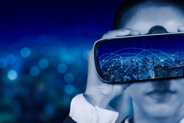 Businesswoman looking at a virtual reality goggle with modern cityscape