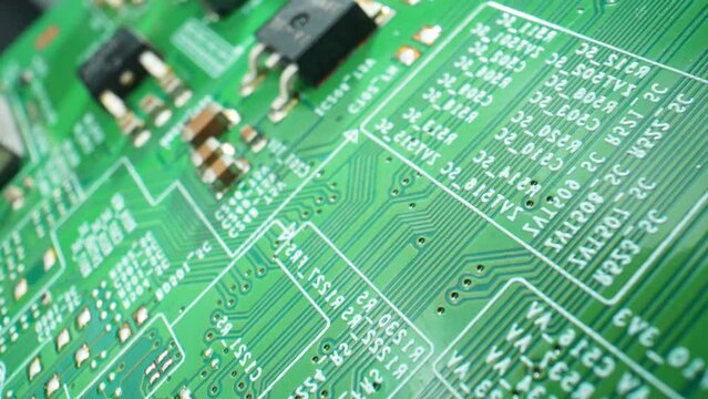Witness intricate circuitry come to life in stunning detail. A mesmerizing macro video reveals the hidden world of a Printed Circuit Board (PCB). Close-up footage. Technology concept.
