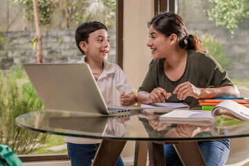 Mother and son use a computer to study and do homework at home.