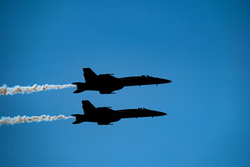 FA-18 Superhornet Jet Silhouettes with white smoke with a blue sky at Sun’N Fun 2023