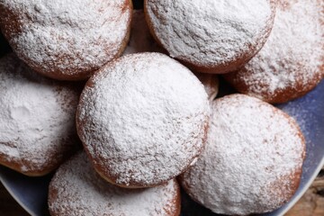 Fototapeta na wymiar Delicious sweet buns with powdered sugar on plate, top view