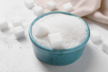 Fototapeta na wymiar Different types of sugar in bowl on white table, closeup